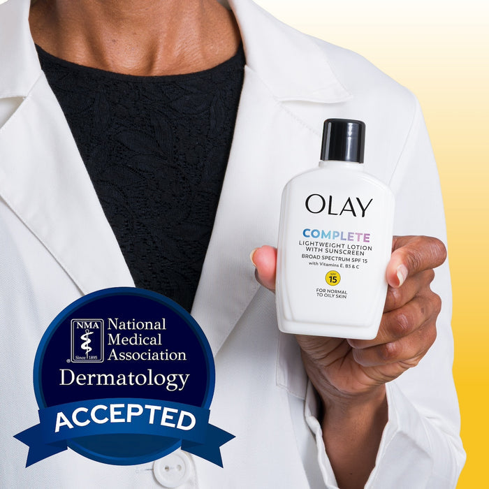 Model wearing lab coat holding Olay Complete Lotion Moisturizer with SPF 15 Normal bottle in hand.