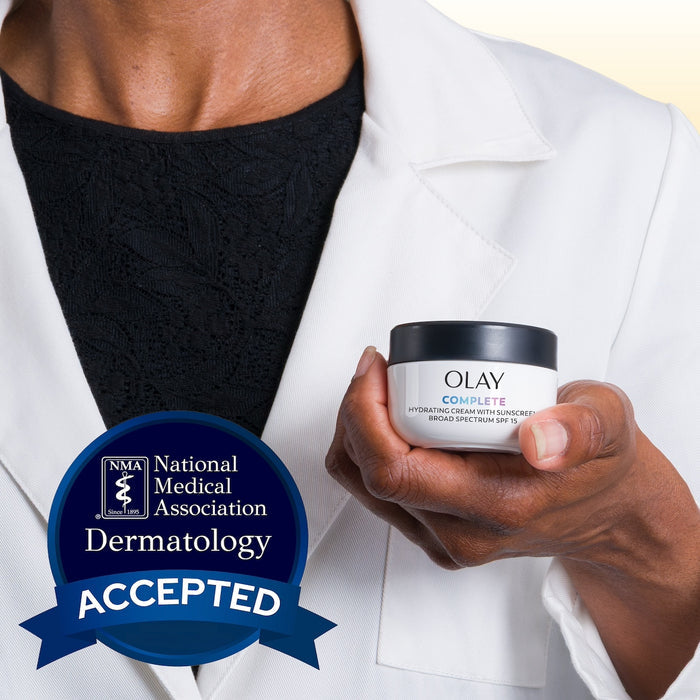 Model wearing lab coat holding Olay Complete Cream Moisturizer with SPF 15 Normal container. National medical association dermatology accepted.