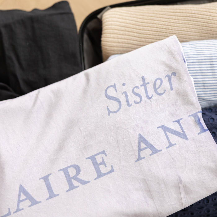Personalized sister missionary blanket packed with luggage, featuring custom missionary details and a soft lavender design.