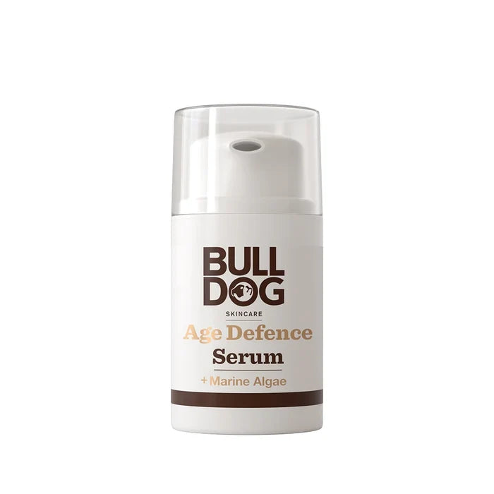 A white and brown bottle of Age Defence Serum with a pump dispenser and clear plastic cap, formulated with natural origin ingredients to reduce fine lines and wrinkles.