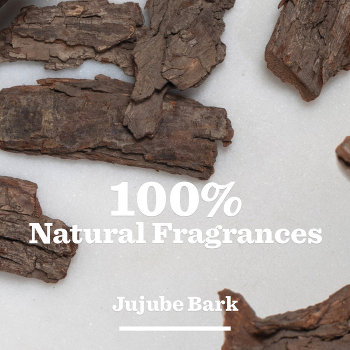 Pieces of brown Jujube Bark on a white surface with text overlay: 100% Natural Fragrances. Experience Anti-Dandruff Shampoo, featuring Jujube Bark known for its natural dandruff relief benefits.