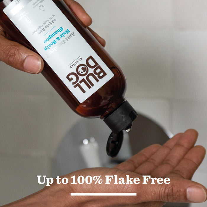 A hand dispenses Anti-Dandruff Shampoo, made with recycled plastic, into the palm. Text below reads: Up to 100% Flake Free.