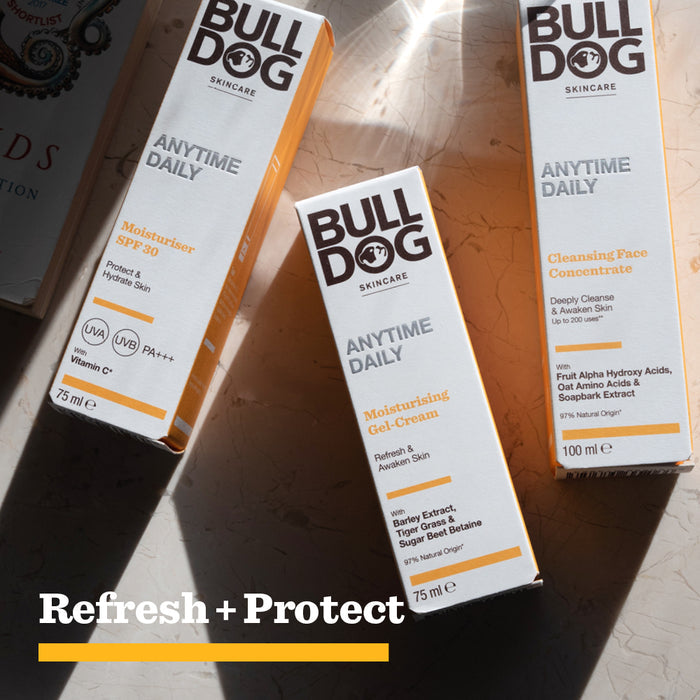 Three Bulldog Skincare products rest on a sunlit surface: Moisturiser SPF 30, Moisturising Gel-Cream, and Anytime Daily Cleansing Face Concentrate with natural origin ingredients. At the bottom, bold text reads: Refresh + Protect in white and yellow.