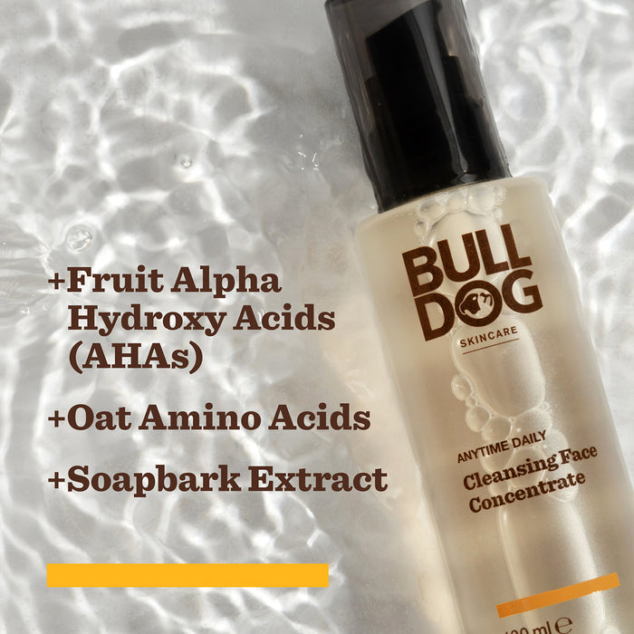 A bottle from the Anytime Daily Collection Bundle on rippled water. Text highlights key natural origin ingredients: Fruit Alpha Hydroxy Acids (AHAs), Oat Amino Acids, and Soapbark Extract.