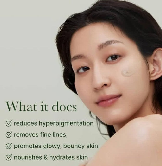 Woman with skin care product on face against a light green background