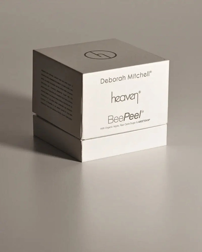 Cube-shaped packaging with 'Deborah Mitchell' and 'heaven BeePeel' branding on a gray background
