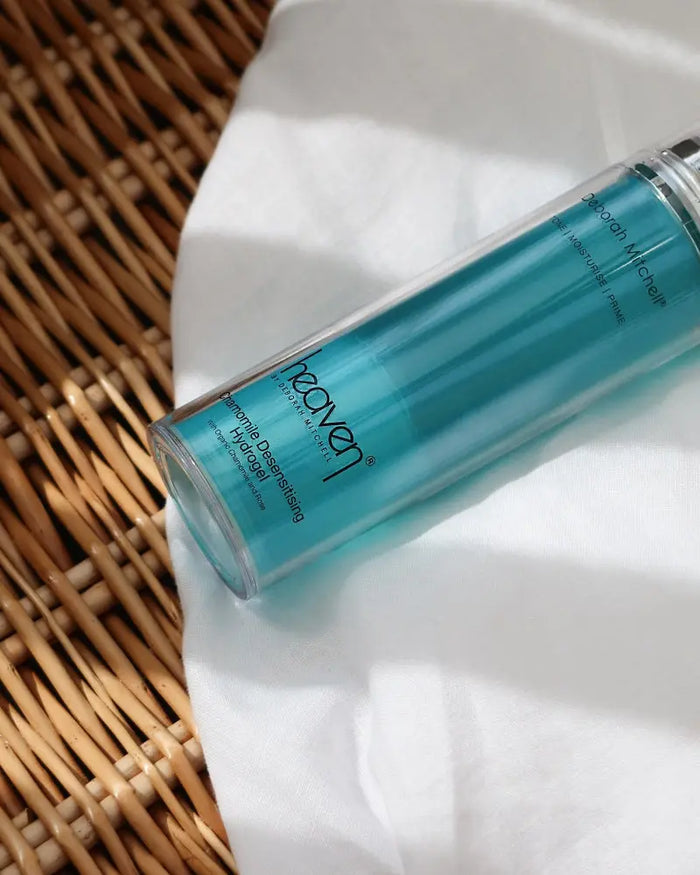 Blue skincare bottle on a white cloth with on a woven wicker basket