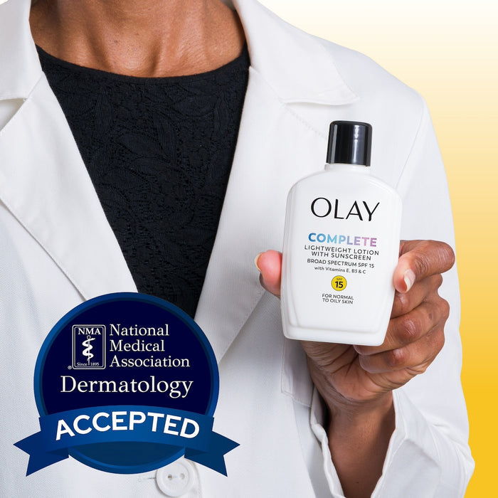 Model wearing lab coat holding Olay Complete Lotion Moisturizer with SPF 15 Normal bottle in hand.
