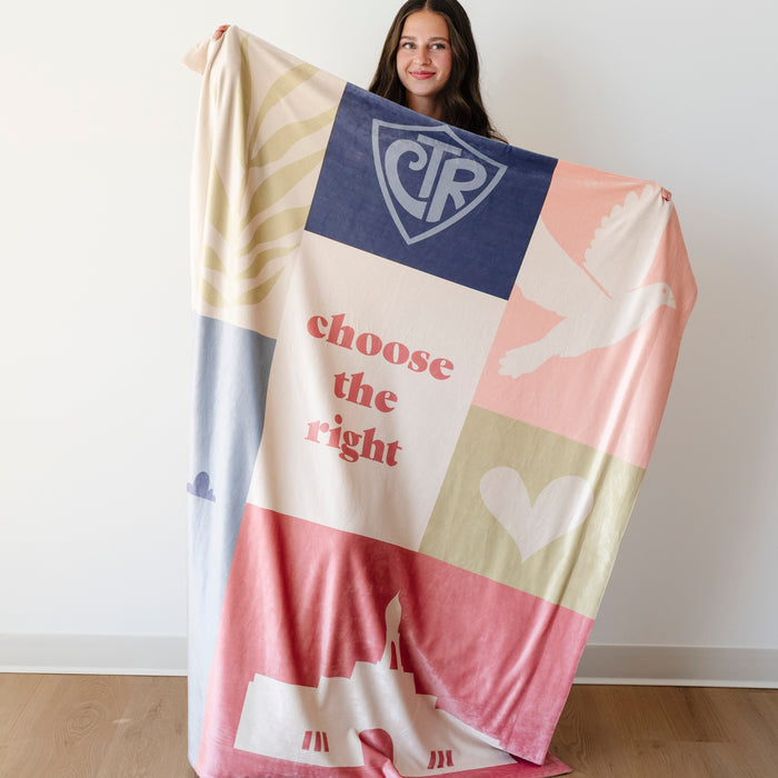 Girl holding a Christian baptism blanket featuring CTR symbols, a temple, dove, and Choose the Right message in a colorful patchwork design.