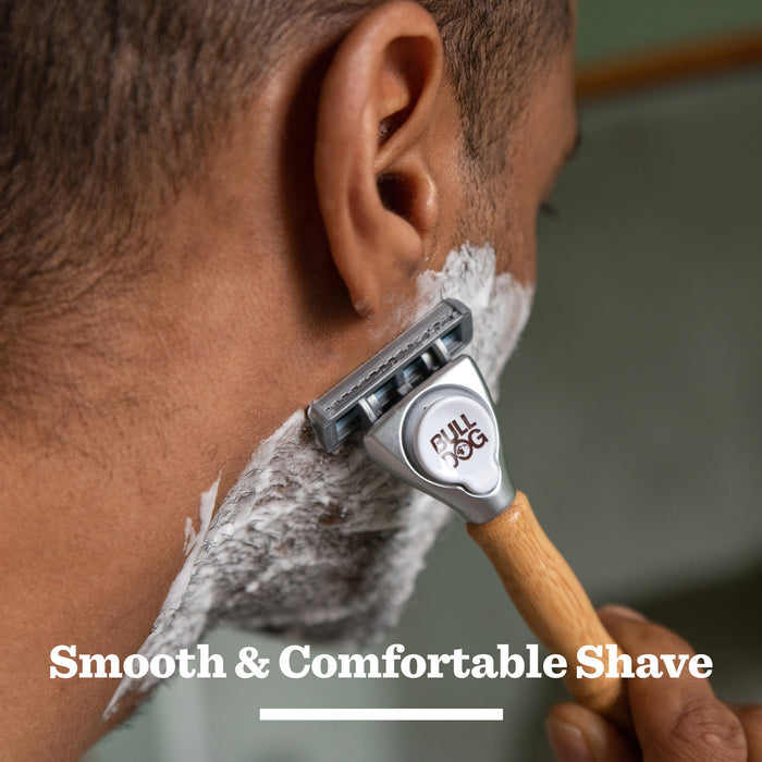 Close-up of a person shaving with the Expert Shave Trio bamboo razor. Shaving cream covers their face, with the text Smooth & Comfortable Shave displayed at the bottom.