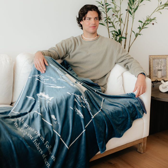 Man wrapped in Fishers of Men Christian blanket featuring Matthew 4:19 scripture – inspirational Christian gift and faith-based throw blanket
