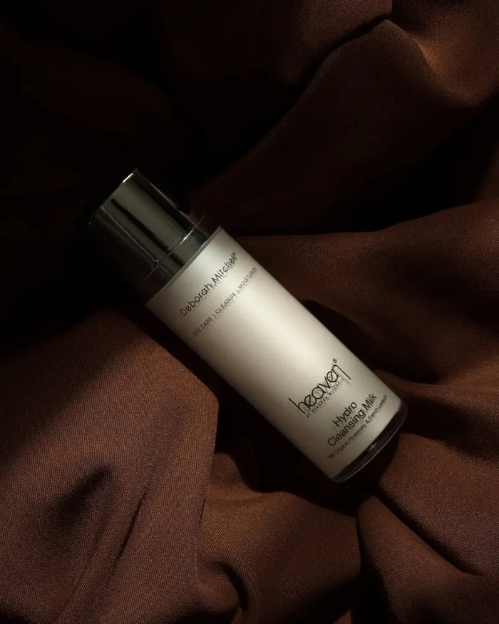 Hydro cleansing milk bottle on a luxurious brown fabric background