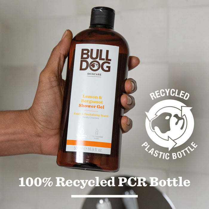 A hand holds a bottle of Lemon & Bergamot Shower Gel made with natural fragrance. The label notes it uses recycled plastic. Text below states: 100% Recycled PCR Bottle—ideal for mens skincare routines.