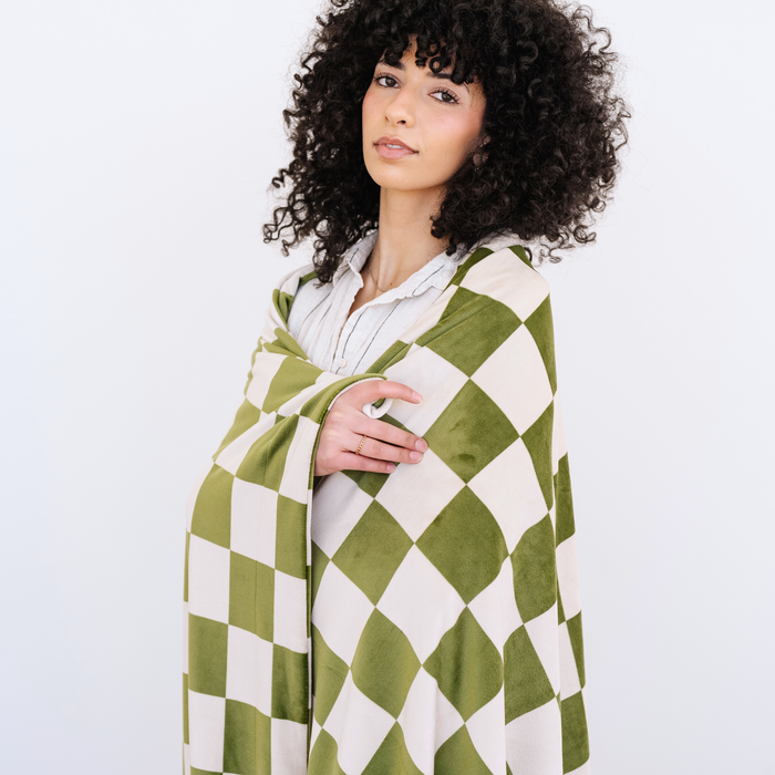 Woman wrapped in an Olive and Cream checkered minky stretch XL blanket.