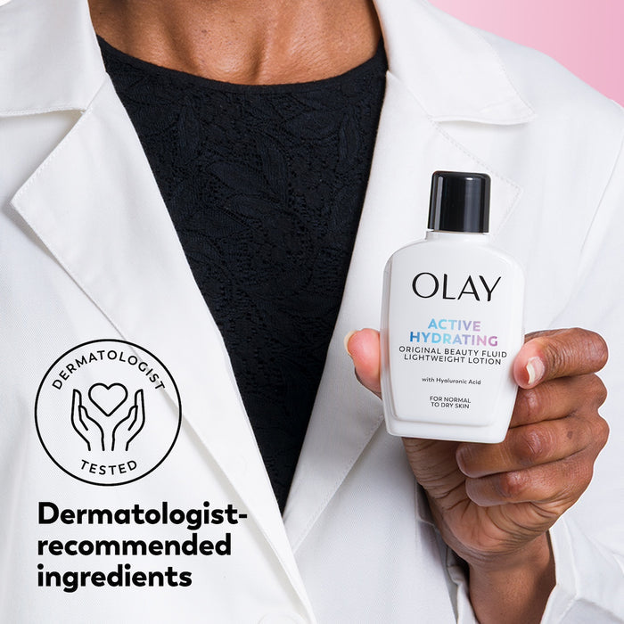 Person holding an Olay skincare product with a dermatologist-tested badge.