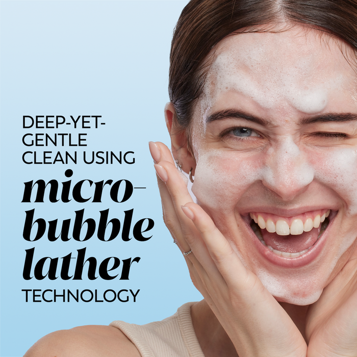 Model posing and smiling while applying melts cleanser to face. Deep yet gentle clean using micro bubble lather technology.