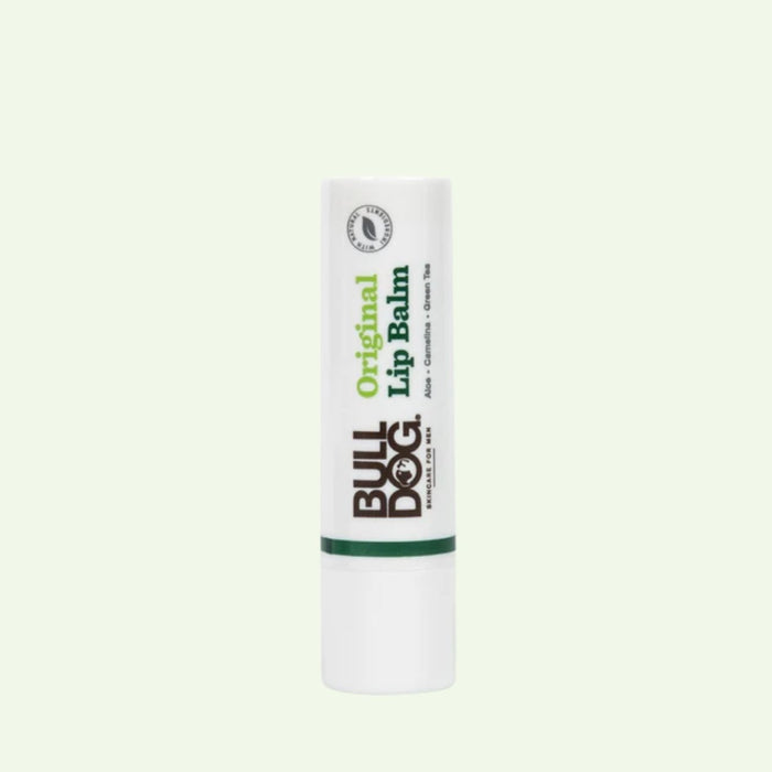 A white tube of Original Lip Balm stands upright against a plain light background. The label features the Bulldog logo and green text, emphasizing its original formula with long-lasting hydration.