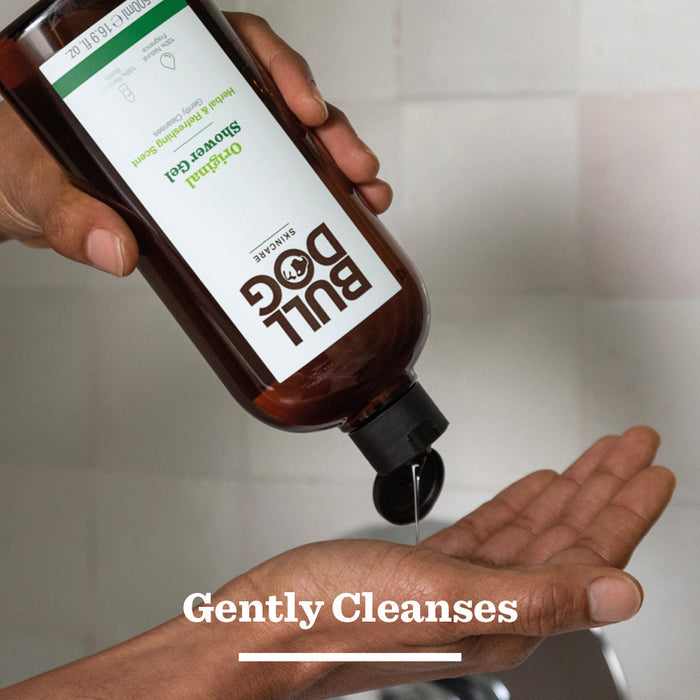A person pours Bull Dog Original Shower Gel from a brown bottle onto their palm over a sink, with Gently Cleanses displayed—an ideal grooming bundle when paired with the Original Mega Bundle.