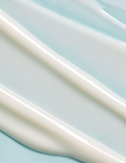 Close-up of smooth white cream swirled on a light blue background