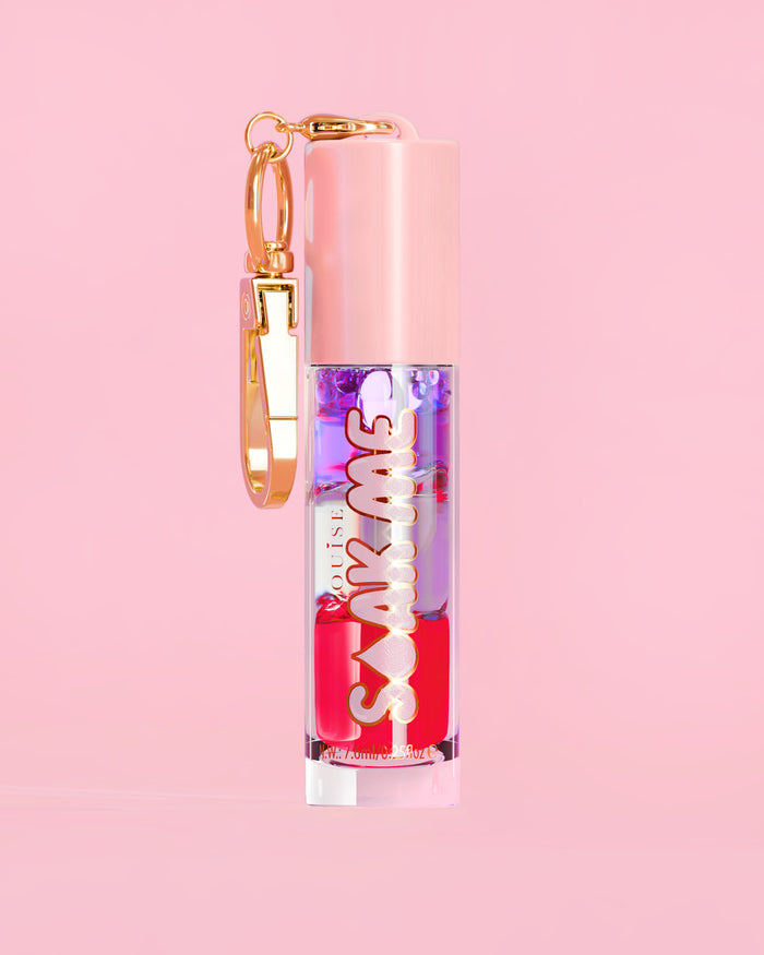 P. Louise Soak Me Lip Oil with colourful layered oil in a pink tube with a gold clasp on a pink background
