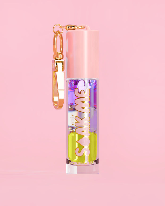 P. Louise Soak Me Lip Oil with colourful layered oil in a pink tube with a gold clasp on a pink background