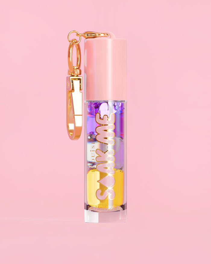 P. Louise Soak Me Lip Oil with colourful layered oil in a pink tube with a gold clasp on a pink background