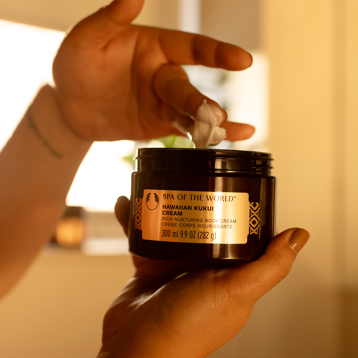 Relaxing Trio set with body wash, radiance oil, and body cream on model's hand