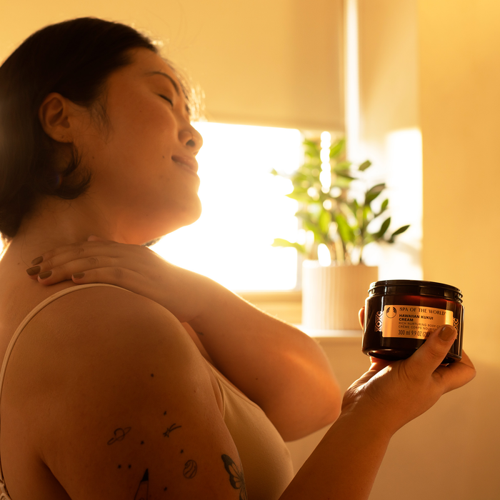 Spa of the World Indulgence Collection on model, featuring body cream, body wash, radiance oil, and scrub.