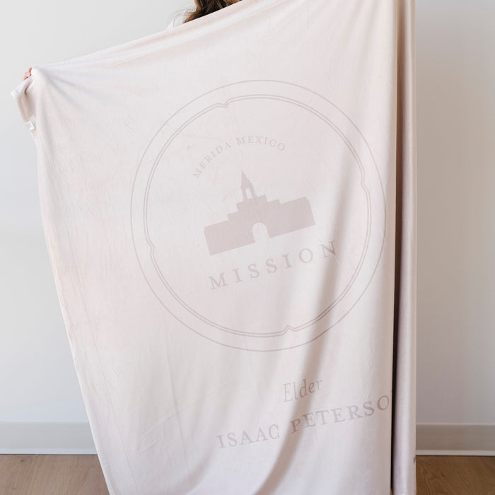 Person holding a personalized missionary blanket featuring the Merida Mexico Mission design, missionary name, and custom mission dates.