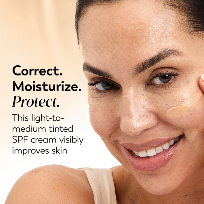 Model posing and smiling applying Total Effects 7 In One CC Tone Correcting Moisturizer SPF 15 to face. Correct. Moisturize. Protect. This light to medium tinted SPF cream visibly improves skin.